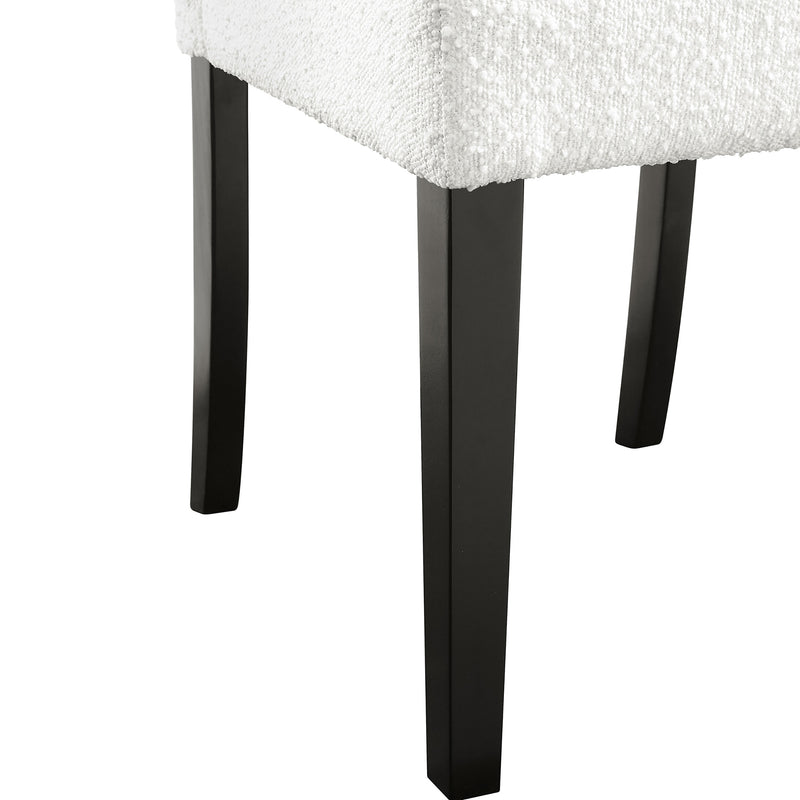 Right facing close up single view of a set of two contemporary black with white boucle dining side chairs on a white background