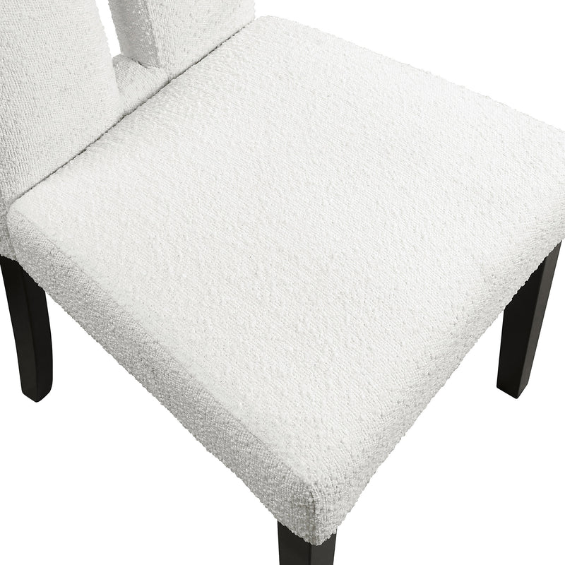 Right facing close up single view of a set of two contemporary black with white boucle dining side chairs on a white background