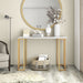 Right angled modern glam white faux marble and gold console table in a living room with accessories
