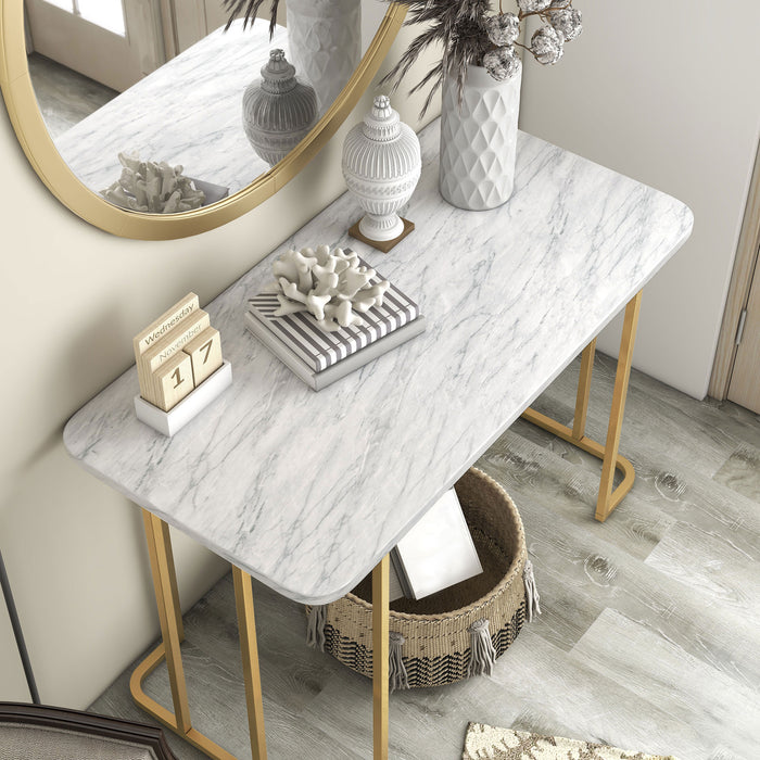 Right angled modern glam white faux marble and gold console table in a living room with accessories