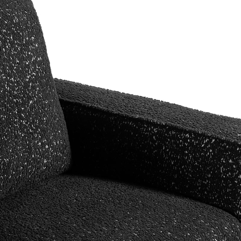 Right facing close up of the inner armrest of a contemporary black and metallic boucle accent armchair on a white background