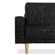 Front facing close up of the armrest, leg and upholstery of a contemporary black and metallic boucle loveseat on a white background