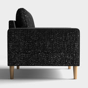 Front facing side view of a contemporary black and metallic boucle sofa on a white background