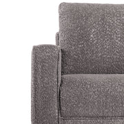 Front facing close up of the armrest and upholstery of a contemporary charcoal gray and metallic boucle accent armchair on a white background