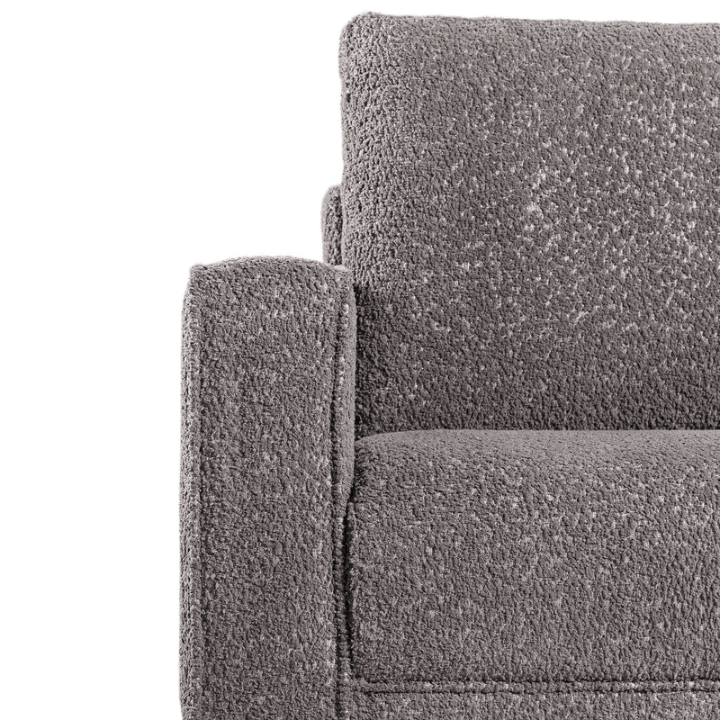Front facing close up of the armrest and upholstery of a contemporary charcoal gray and metallic boucle accent armchair on a white background