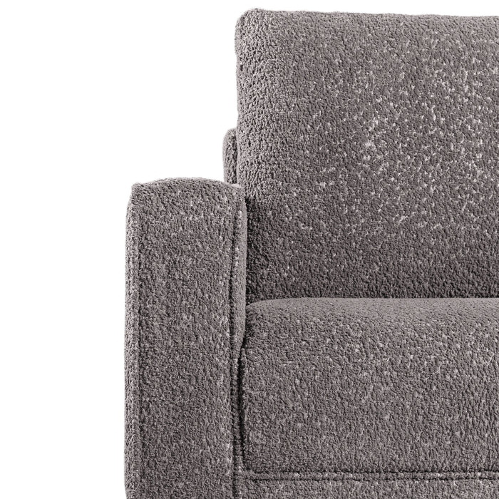 Front facing close up of the armrest and upholstery of a contemporary charcoal gray and metallic boucle sofa on a white background