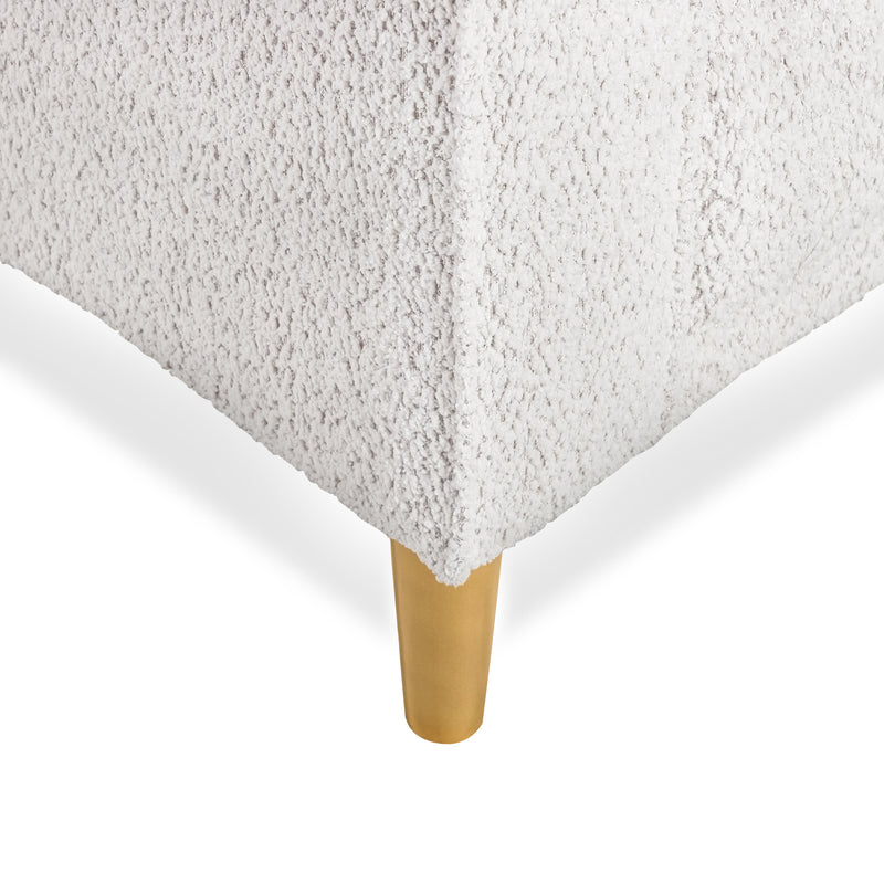 Right facing close up of the leg and upholstery of a contemporary off-white metallic boucle accent armchair on a white background
