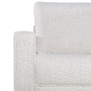Front facing close up of the armrest and upholstery of a contemporary off-white metallic boucle loveseat on a white background