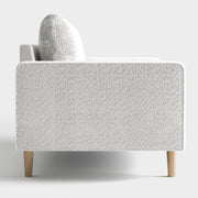 Front facing side view of a contemporary off-white metallic boucle loveseat on a white background