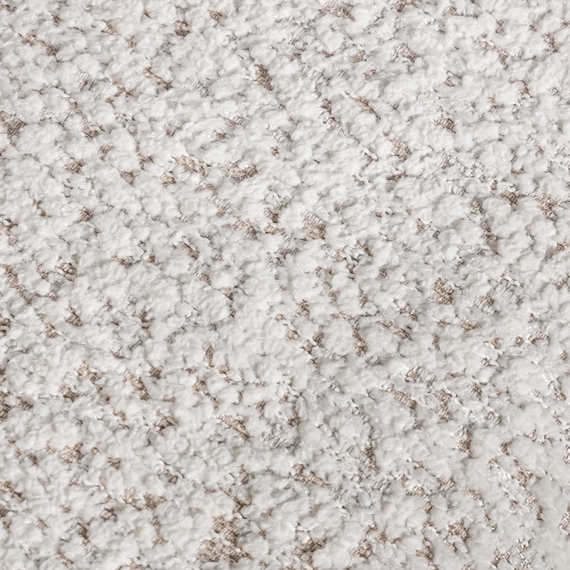 Swatch of the upholstery fabric on a contemporary off-white metallic boucle sofa