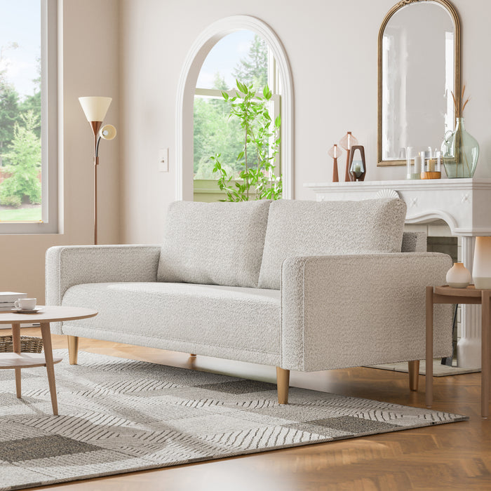 Left facing contemporary off-white metallic boucle sofa in a room with accessories
