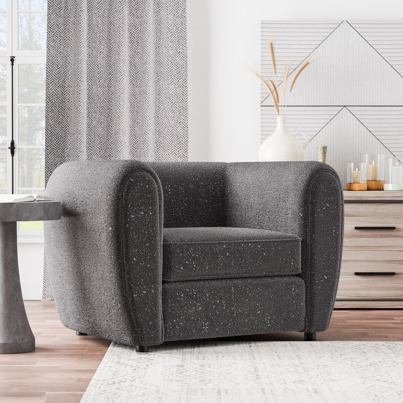 Right facing contemporary charcoal gray metallic boucle shelter armchair in a room with accessories