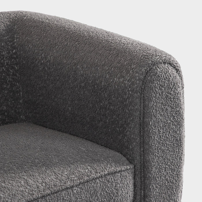 Right facing close up of the inner armrest of a contemporary charcoal gray metallic boucle shelter armchair on a white background