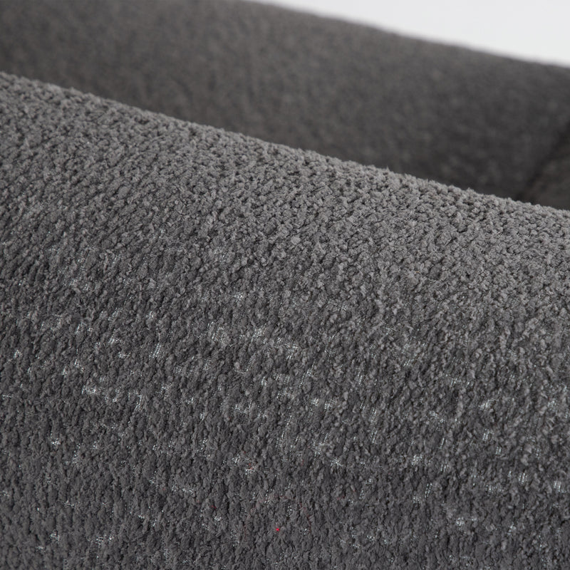 Right facing close up of the rounded back of a contemporary charcoal gray metallic boucle shelter armchair on a white background
