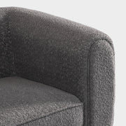 Right facing close up of the inner armrest of a contemporary charcoal gray metallic boucle shelter loveseat on a white background