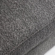Right facing close up of the seat cushion of a contemporary charcoal gray metallic boucle shelter loveseat on a white background