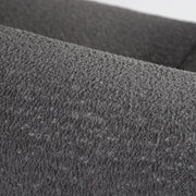 Right facing close up of the rounded back of a contemporary charcoal gray metallic boucle shelter loveseat on a white background