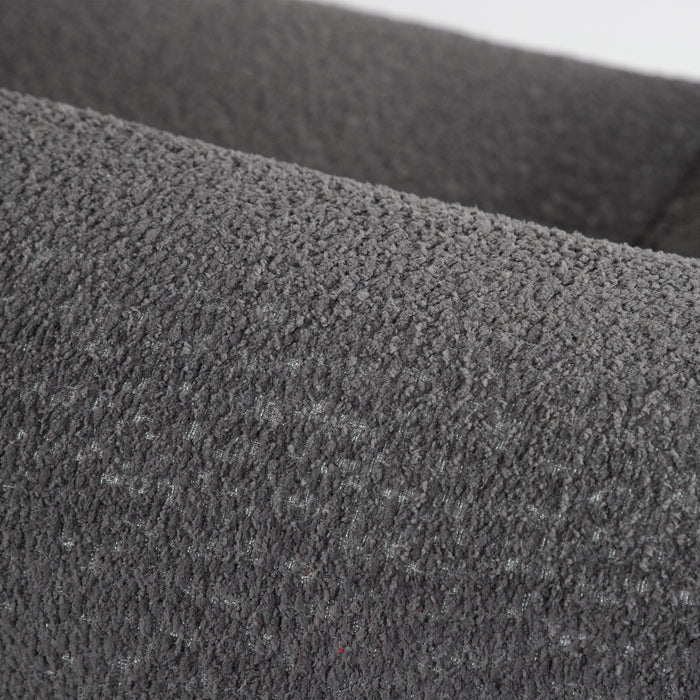 Right facing close up of the rounded back of a contemporary charcoal gray metallic boucle shelter sofa on a white background