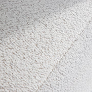 Swatch of the upholstery fabric on a contemporary off-white metallic boucle shelter armchair