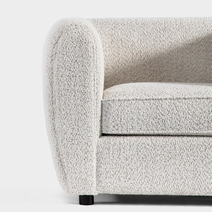 Front facing close up of the armrest and leg of a contemporary off-white metallic boucle shelter loveseat on a white background