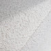 Swatch of the upholstery fabric on a contemporary off-white metallic boucle shelter loveseat