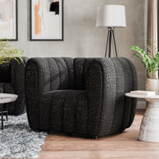 Left facing contemporary black and metallic boucle tufted shelter armchair in a living room with accessories