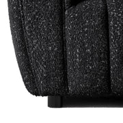 Front facing close up armrest and leg of a contemporary black and metallic boucle tufted shelter armchair on a white background