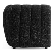 Front facing side view of a contemporary black and metallic boucle tufted shelter sofa on a white background