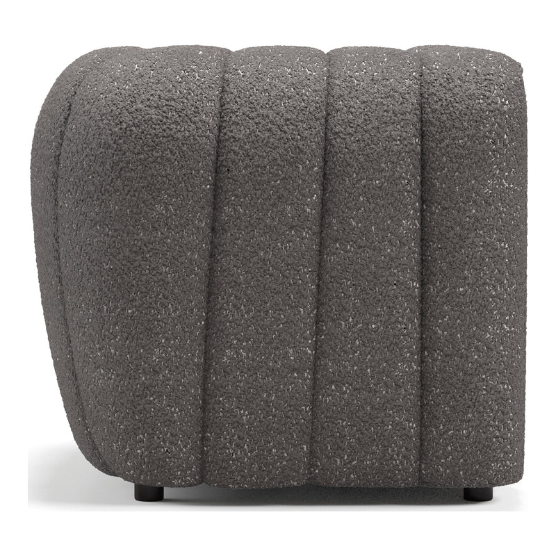 Front facing side view of a contemporary charcoal gray and metallic boucle tufted shelter armchair on a white background