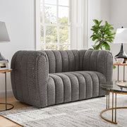 Right facing contemporary charcoal gray and metallic boucle tufted shelter loveseat in a living room with accessories