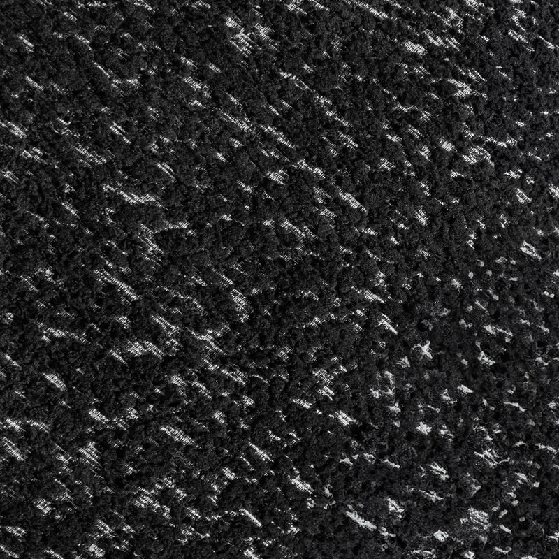 Swatch of the upholstery fabric on a contemporary black and metallic boucle curved kidney armchair