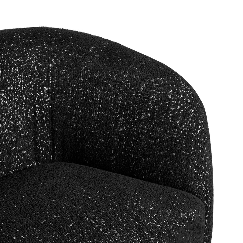 Right facing close up view of the inner armrest on a contemporary black and metallic boucle curved kidney armchair on a white background