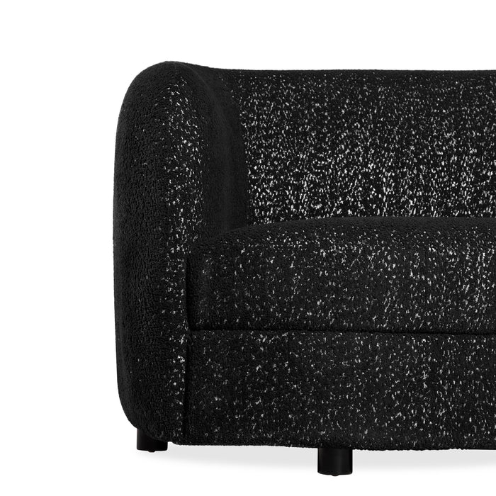 Front facing close up view of the leg and armrest on a contemporary black and metallic boucle curved kidney loveseat