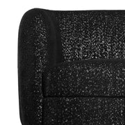 Front facing close up view of the upholstery and armrest on a contemporary black and metallic boucle curved kidney sofa