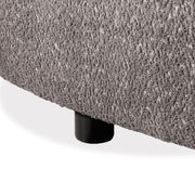 Left facing close up view of the leg on a contemporary charcoal gray and metallic boucle curved kidney armchair on a white background