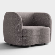 Right facing contemporary charcoal gray and metallic boucle curved kidney armchair on a white background