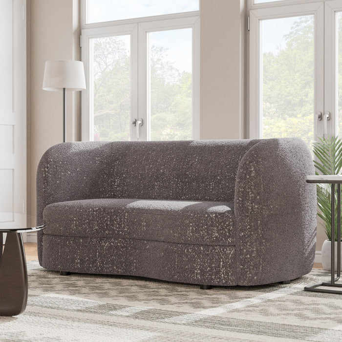 Left facing contemporary charcoal gray and metallic boucle curved kidney loveseat in a room with accessories