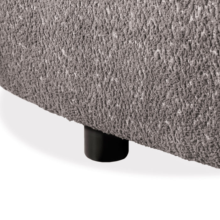 Left facing close up view of the leg on a contemporary charcoal gray and metallic boucle curved kidney loveseat on a white background