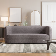 Front facing contemporary charcoal gray and metallic boucle curved kidney sofa in a room with accessories