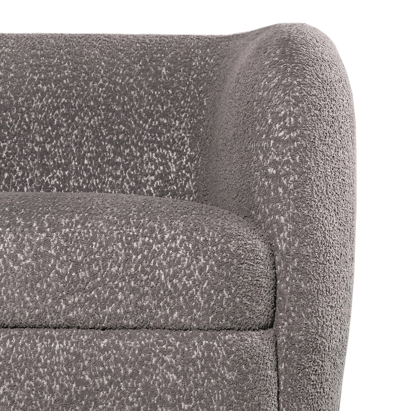 Front facing close up view of the upholstery and armrest on a contemporary charcoal gray and metallic boucle curved kidney sofa on a white background