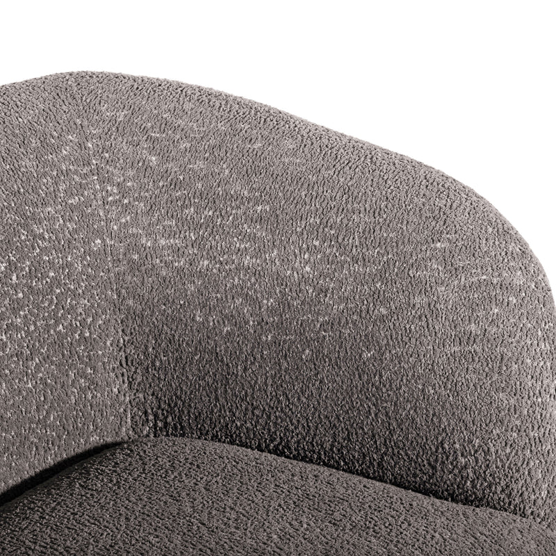 Right facing close up view of the inner armrest on a contemporary charcoal gray and metallic boucle curved kidney sofa on a white background