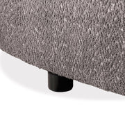 Left facing close up view of the leg on a contemporary charcoal gray and metallic boucle curved kidney sofa on a white background