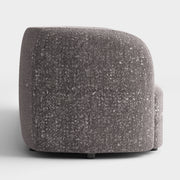 Front facing side view of a contemporary charcoal gray and metallic boucle curved kidney sofa on a white background