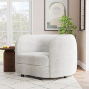 Left facing contemporary off-white metallic boucle curved kidney armchair in a room with accessories