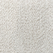 Swatch of the upholstery fabric on a contemporary off-white metallic boucle curved kidney armchair