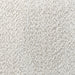 Swatch of the upholstery fabric on a contemporary off-white metallic boucle curved kidney loveseat