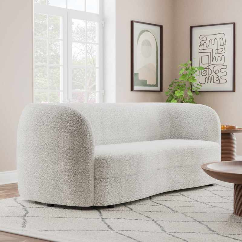 Right facing contemporary off-white metallic boucle curved kidney sofa in a room with accessories