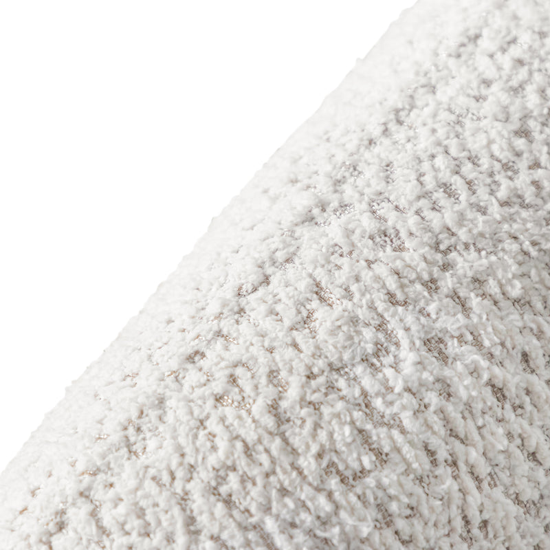 Right facing close up view of the upholstery and back on a contemporary off-white metallic boucle curved kidney sofa on a white background