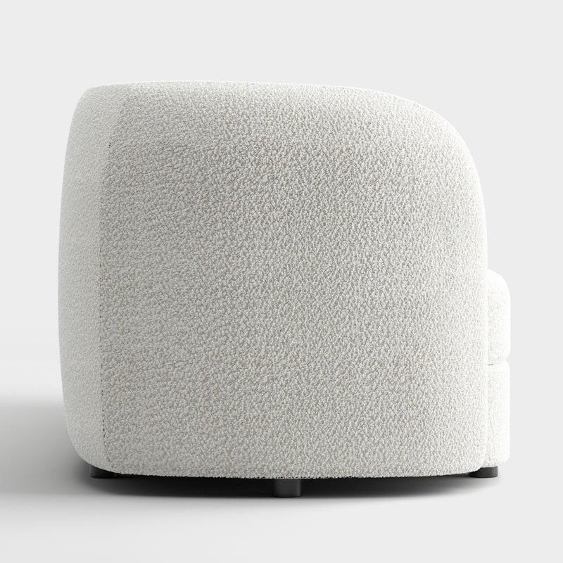 Front facing side view of a contemporary off-white metallic boucle curved kidney sofa on a white background