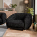 Left facing contemporary black chenille sloping tuxedo accent armchair in a room with accessories